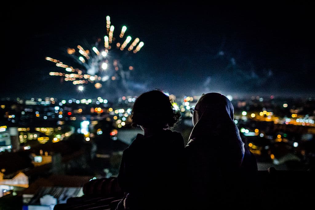 En Yogyakarta,
<b> Indonesia</b>, una mujer y su hijo observan desde una azotea los fuegos artificiales al empezar el año.