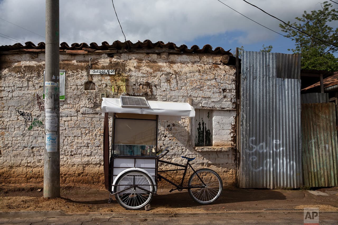 El maestro Gerardo Ixcoy estaciona su aula móvil justo afuera de la puerta de la casa de uno de sus estudiantes, en Santa Cruz del Quiché, 
<a href="https://www.univision.com/temas/guatemala">Guatemala</a>. 
<b> Además, Ixcoy -mejor conocido desde la infancia como 'Lalito 10' ha instalado una pizarra y un pequeño panel solar que alimenta un reproductor de audio que usa para algunas lecciones.</b>
