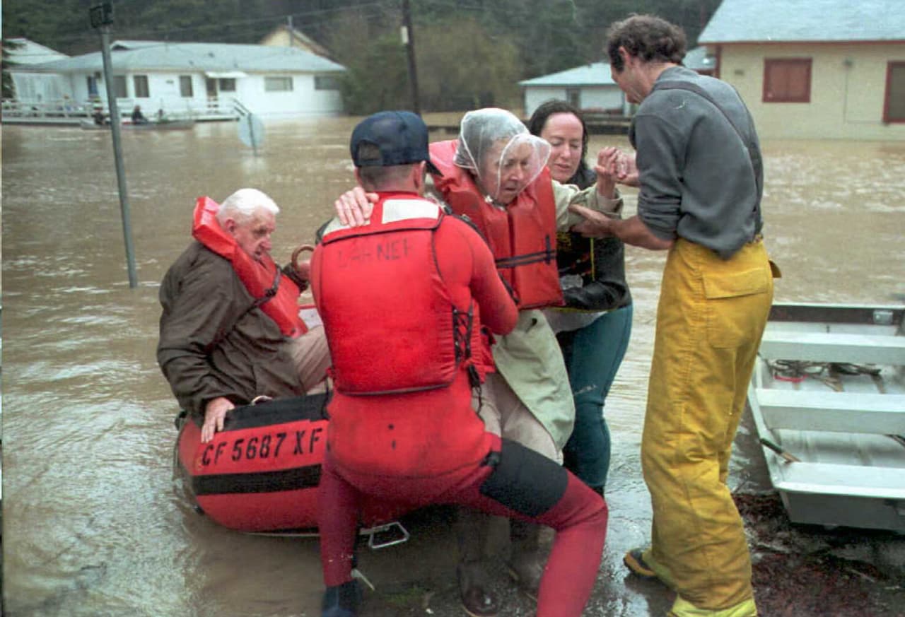 Los bomberos de Monte Río rescatan a una familia cuya vivienda quedó afectada por las inundaciones de enero de 1995 en el norte de California.
