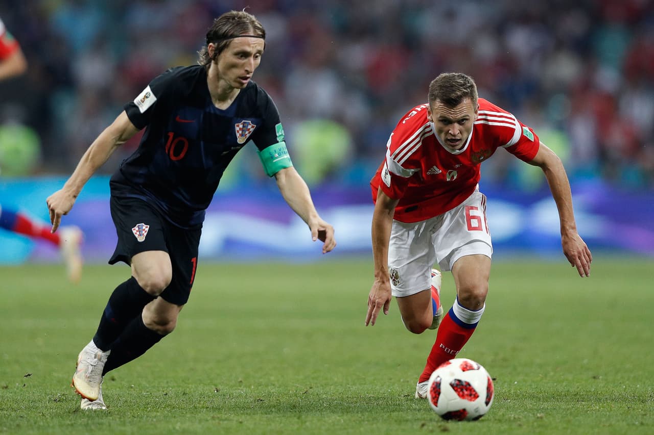 Denis Cheryshev (derecha), autor del primer gol de Rusia al minuto 31', fue superado en esta acción por Modric quien comenzó a manejar la pelota en el segundo tiempo.