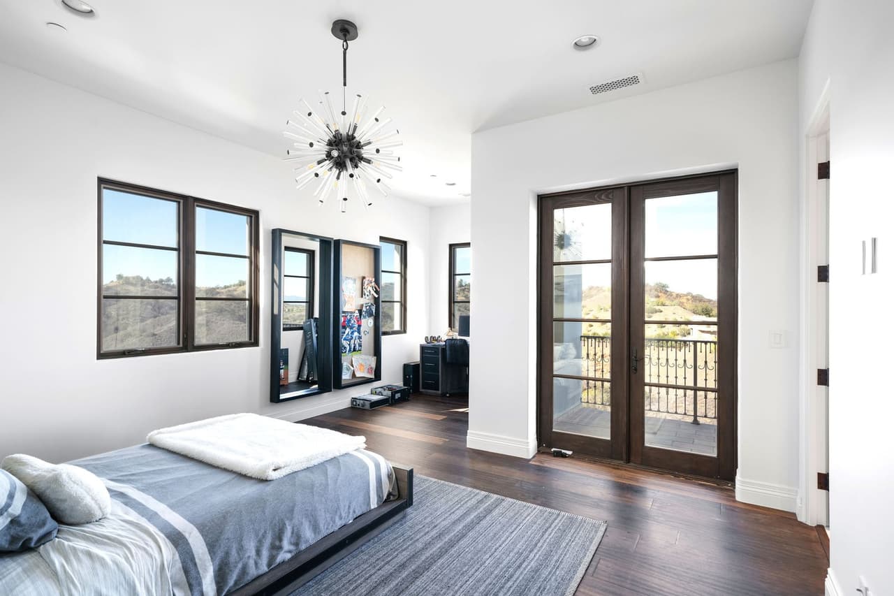 El dormitorio principal tiene un balcón privado, un vestidor y un baño estilo spa con una bañera para dos personas.