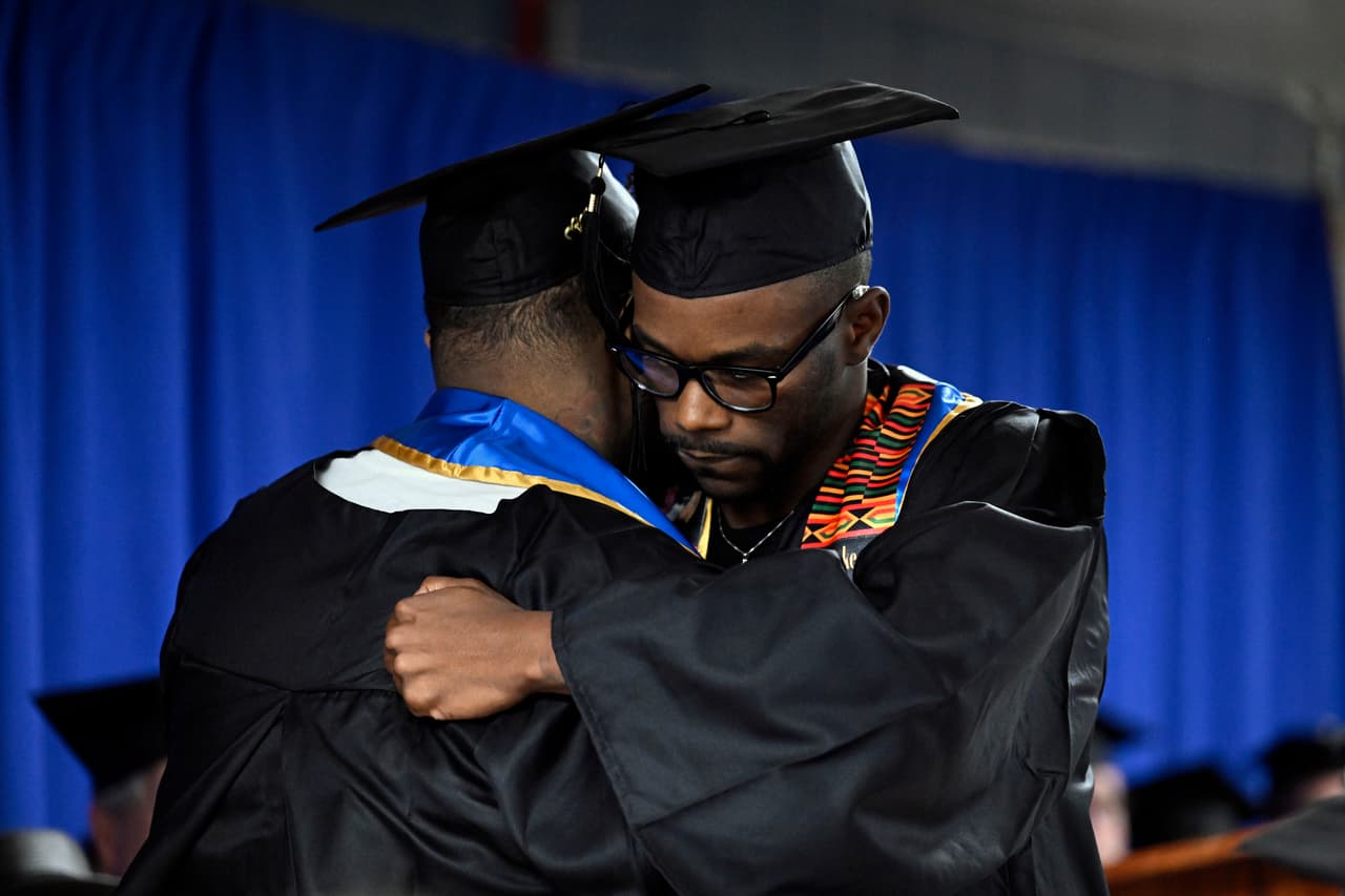 Alpha Jalloh, izquierda, y Marcus Harvin, derecha, se abrazan en la primera ceremonia de graduación universitaria en la Institución Correccional MacDougall-Walker, el viernes 9 de junio de 2023, en Suffield, Connecticut. La ceremonia se llevó a cabo bajo una asociación establecida en 2021 por la Universidad de New Haven y la Iniciativa de Educación en Prisiones de Yale.