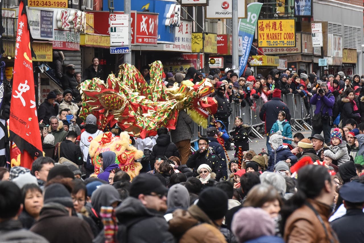 Un grupo de personas observa el desfile en Chinatown.