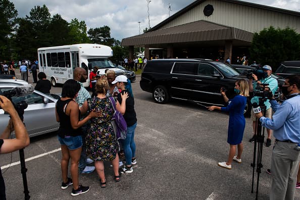 Un grupo de personas ora frente a la iglesia donde se hacen los actos en homenaje a Floyd.