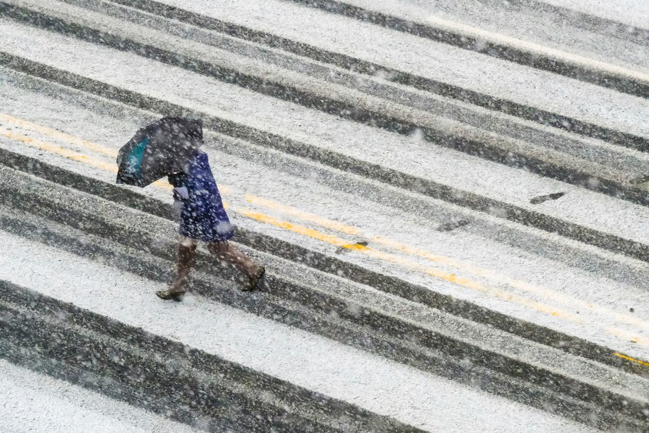 Un peatón cruza una calle nevada en Washington DC. Según los pronósticos esta tormenta arrojará más Nieve sobre Washington, Filadelfia y Nueva York que las tres tormentas anteriores combinadas.
