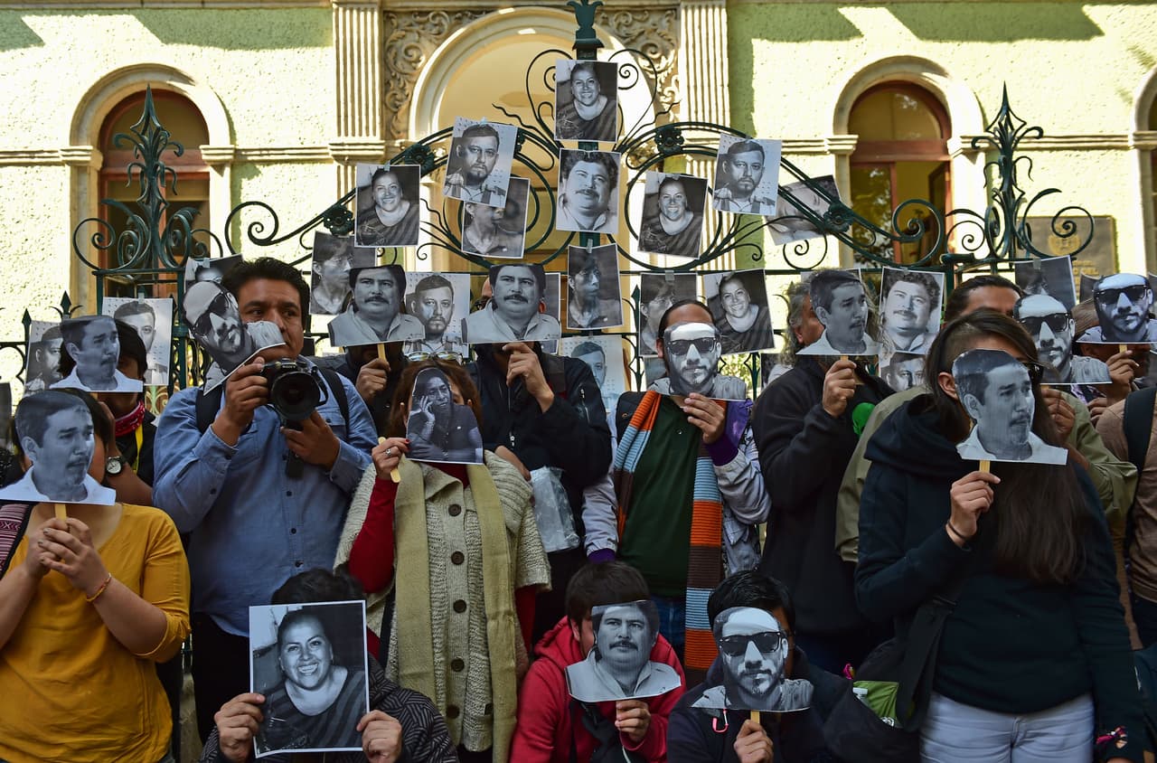 Periodistas mexicanos posan con imágenes de periodistas muertos a las puertas de la oficina de representación del estado de Veracruz, en la capital, días despúes de la muerte de la reportera Anabel Flores Salazar, que fue secuestrada y asesinada.