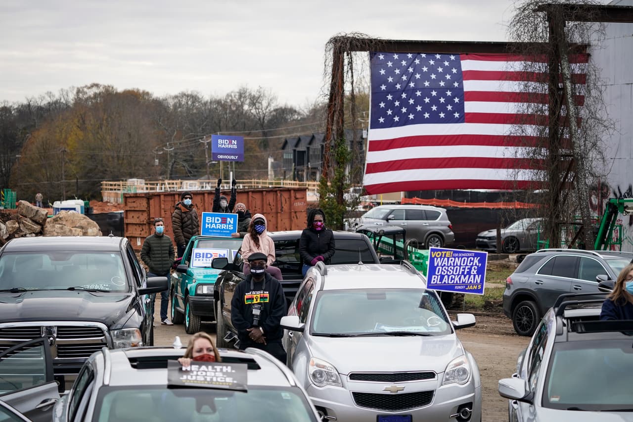 Los seguidores escuchan desde sus autos mientras el candidato demócrata al Senado de Estados Unidos, Jon Ossoff, pronuncia sus comentarios durante un mitin de campaña con el presidente electo de Estados Unidos, Joe Biden, en el Pullman Yard. El presidente agradeció la confianza y haberle permitido ganar un estado tradicionalmente conservador.