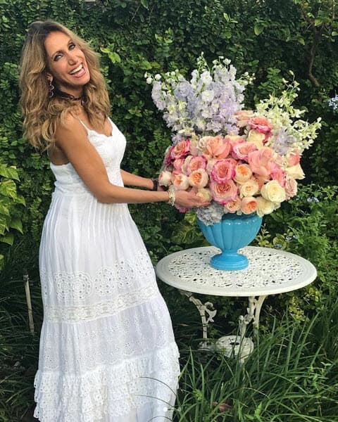 14. A Lili le encantan las flores, por eso posó con este arreglo de rosas utilizando un vestido blanco muy fresco.