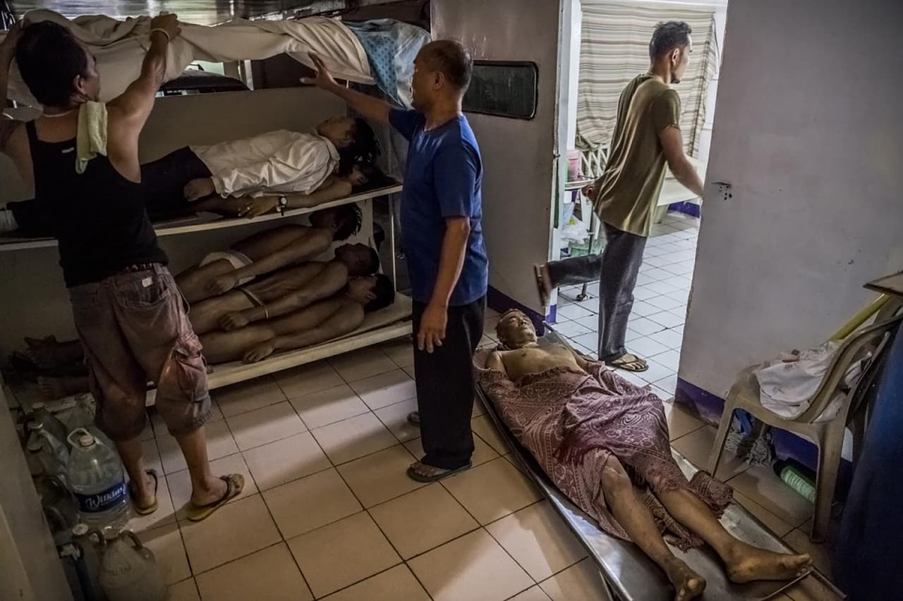 <b>La guerra contra el narcotráfico en Filipinas.</b> En la morgue los cuerpos estaban apilados como leña. El hombre en el suelo, Danilo Deparine, de 36 años, fue encontrado muerto bajo un puente. Una semana después que su hermano menor, Aljon, de 23 años, tuviera el mismo destino. A su madre, María Mesa Deparine, le tomó tres semanas juntar préstamos y donaciones por un total de 50.000 pesos filipinos ( 1,030 dólares) para el funeral de Aljon. Luego negoció un recorte de 12.000 pesos (240 dólares) para enterrar a Danilo.