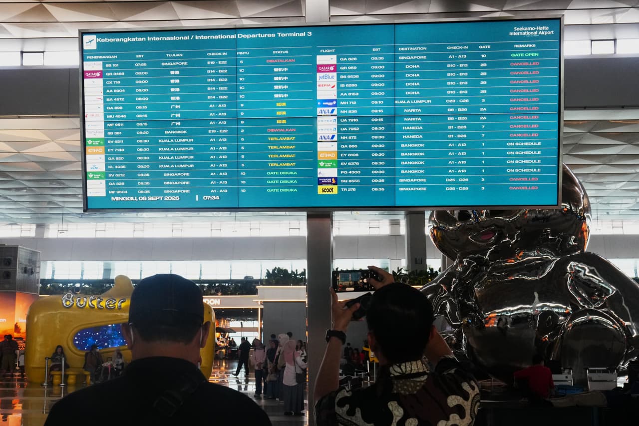Los viajeros pasan junto a un panel informativo que muestra vuelos interrumpidos en el Aeropuerto Internacional Soekarno-Hatta en Tangerang, Indonesia, el domingo 6 de septiembre de 2026.