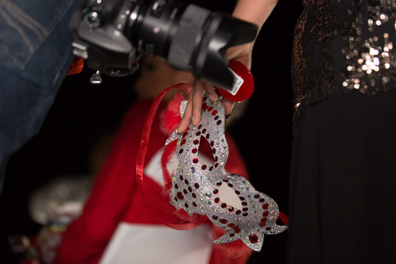 Una cámara al lado de una máscara del festejo de los XV de Rubí.