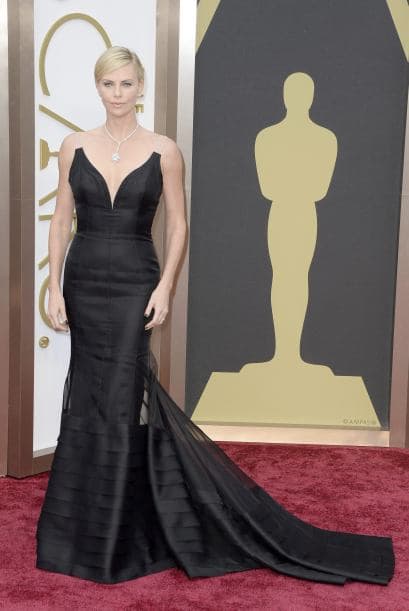 La actriz sudafricana Charlize Theron luciendo un vestido de Dior en negro con hombreras transparentes. Tampoco defraudó la sofisticación de Charlize Theron, esta vez con un Dior de negro, hasta los pies y joyería de Harry Winston por valor de más de diez millones de dólares