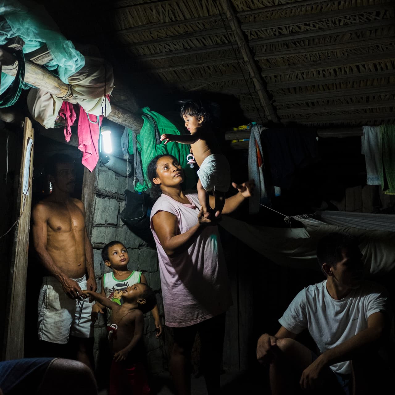 Los extractivistas viven hoy en día en las orillas del río con una economía basada en la explotación de los recursos de la selva como el oro, los aceites y los frutos del Amazonas. En la imagen Veia juega con su hija mientras su esposo David en su casa de la Reserva de Extractavistas de Riozinho do Anfrísio.