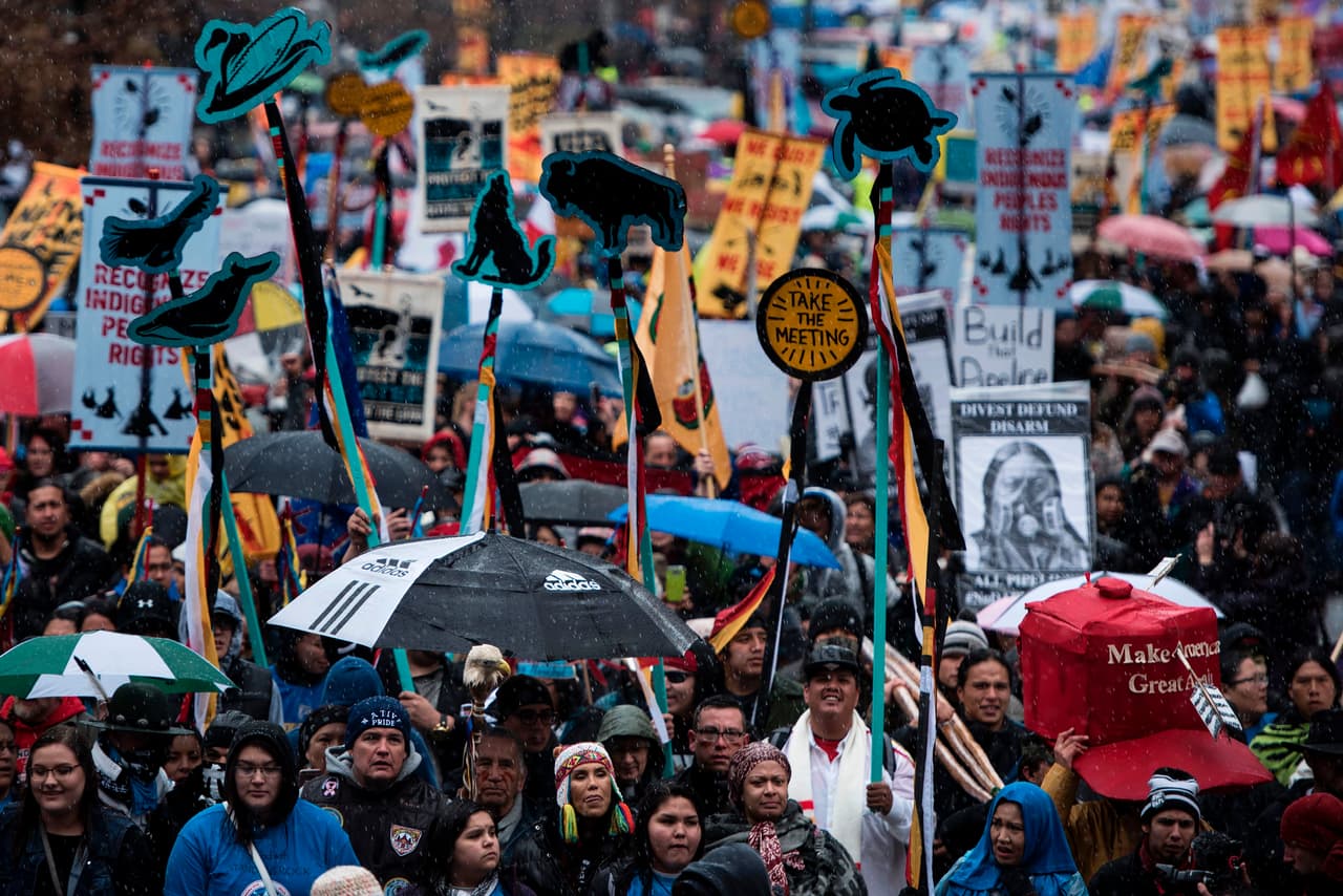 Los activistas, en manifestación por los derechos de los nativos americanos, pasan por delante del Departamento del Tesoro de Estados Unidos durante la protesta 'Native Nations Rise' el 10 de marzo de 2017 en Washington, DC. Las tribus nativas de todo Estados Unidos se reunieron durante cuatro días de protestas contra la administración del presidente estadounidense Donald Trump y el oleoducto Dakota Access.