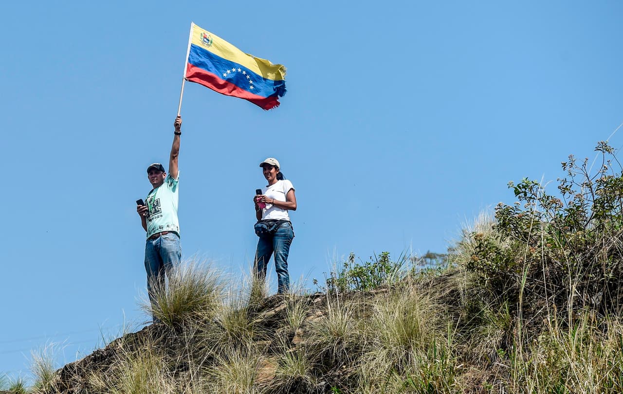 Desde una colina en el oeste de Caracas, un grupo de opositores que ya había llegado al destino final de la protesta en una zona popular espera a quienes aún caminaban desde distintos puntos de la ciudad. (Juan Barreto/AFP/GettyImages)