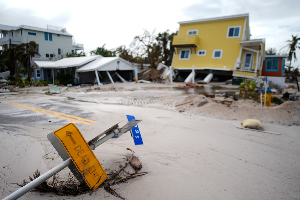 Una casa derribada de sus pilotes después del paso del huracán Milton, junto a un terreno vacío donde una casa fue arrastrada por el huracán Helene, en Bradenton Beach en Anna Maria Island, Florida, el jueves 10 de octubre de 2024.