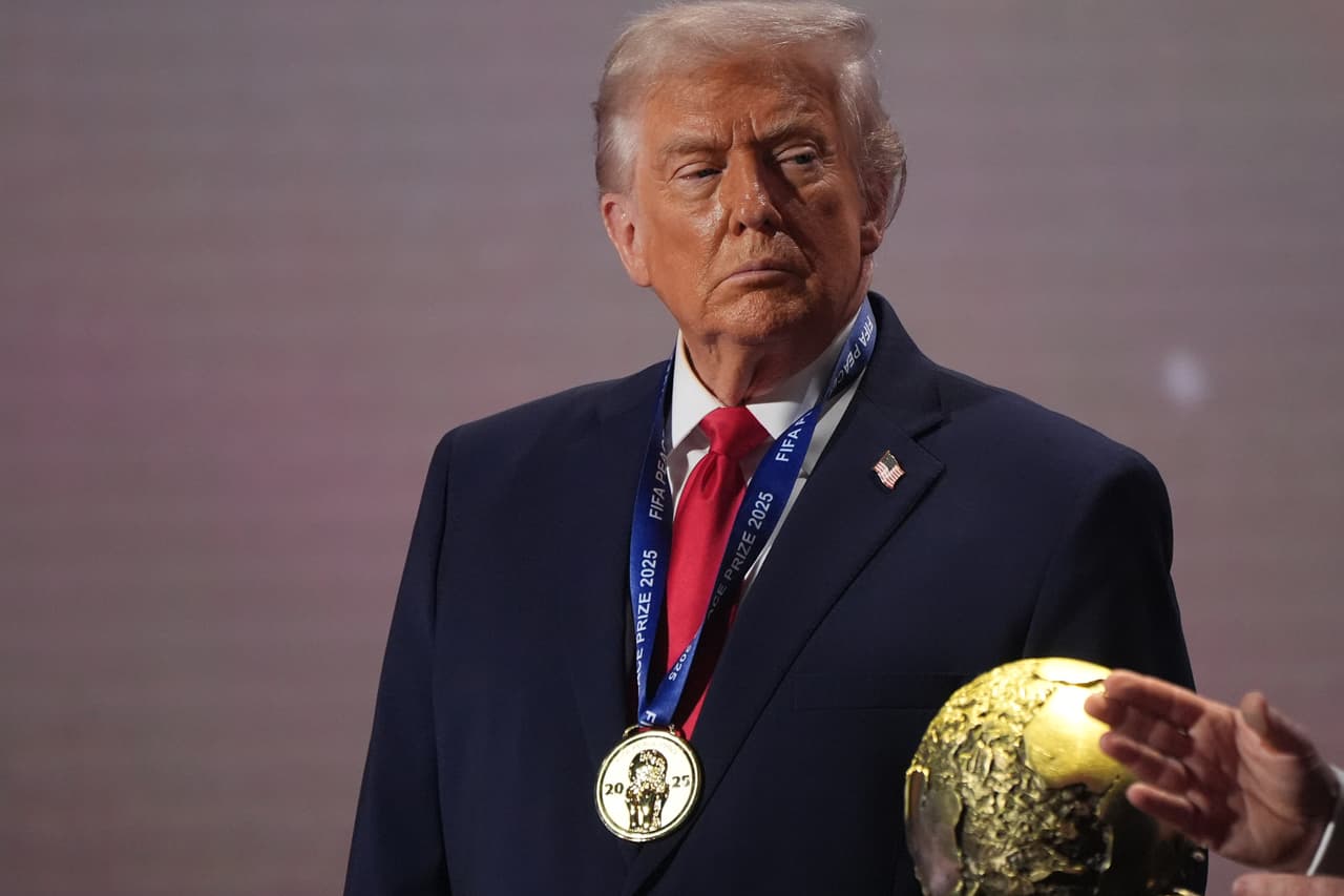 Donald Trump sostiene un balón y una medalla durante una ceremonia deportiva. Como presidente, ha participado en diversos eventos de alcance internacional celebrados en Estados Unidos.