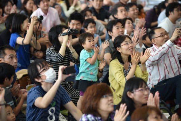 Visiblemente emocionados, estos espectadores aplauden luego de que Japón lograra poner en órbita un satélite con total éxito.