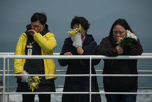 A un año del hundimiento del ferry surcoreano Sewol, familiares de las 304 víctimas los recordaron en el sitio de la tragedia, lanzando flores blancas al mar y reclamando recuperar los nueve cuerpos aún desaparecidos.