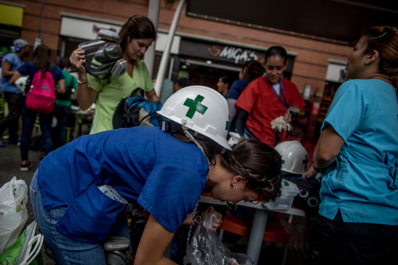 Doctors and volunteers meet close to where the demonstrations begin. At the San Ignacio Center, a mall in east Caracas, rescuers distribute medical supplies before one of the protests.
