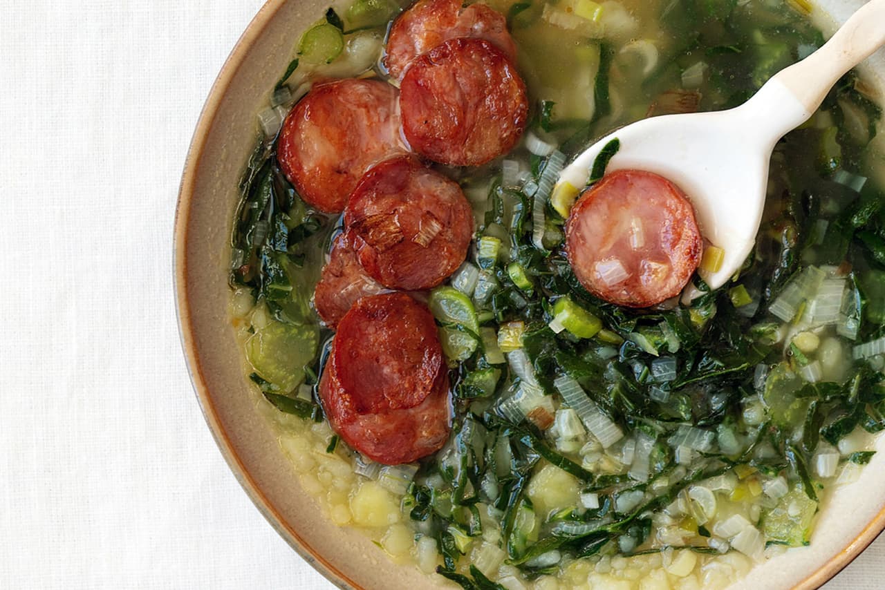 <b>Caldo verde</b>
<br>
<br>
<b>Origen: Portugal</b>
<br>
<br>Para hacer esta sopa originaria de la región vinícola de Minho se combinan verduras en rodajas finas con papas y cebollas. Es una estrella culinaria en los cafés exclusivos y las cocinas rurales, un símbolo de la comida casera reconfortante. Versiones de este plato agregan salchichas portuguesas, sumando un sabor ahumado y salado que la hace más sustanciosa.
<br>
<br>Las sopas siempre han sido consideradas alimentos
<a href="https://www.univision.com/delicioso/9-recetas-de-sopas-deliciosas-y-nutritivas-para-el-frio"><u>reconfortantes, reconstituyentes y hasta curativos</u></a>, una herramienta para mitigar el frío o un malestar. Un reportaje de la revista
<i>Psychology Today</i> cita a expertos han encontrado que su consumo se asocia al cuidado, la comodidad, la compañía y las relaciones positivas.
<br>