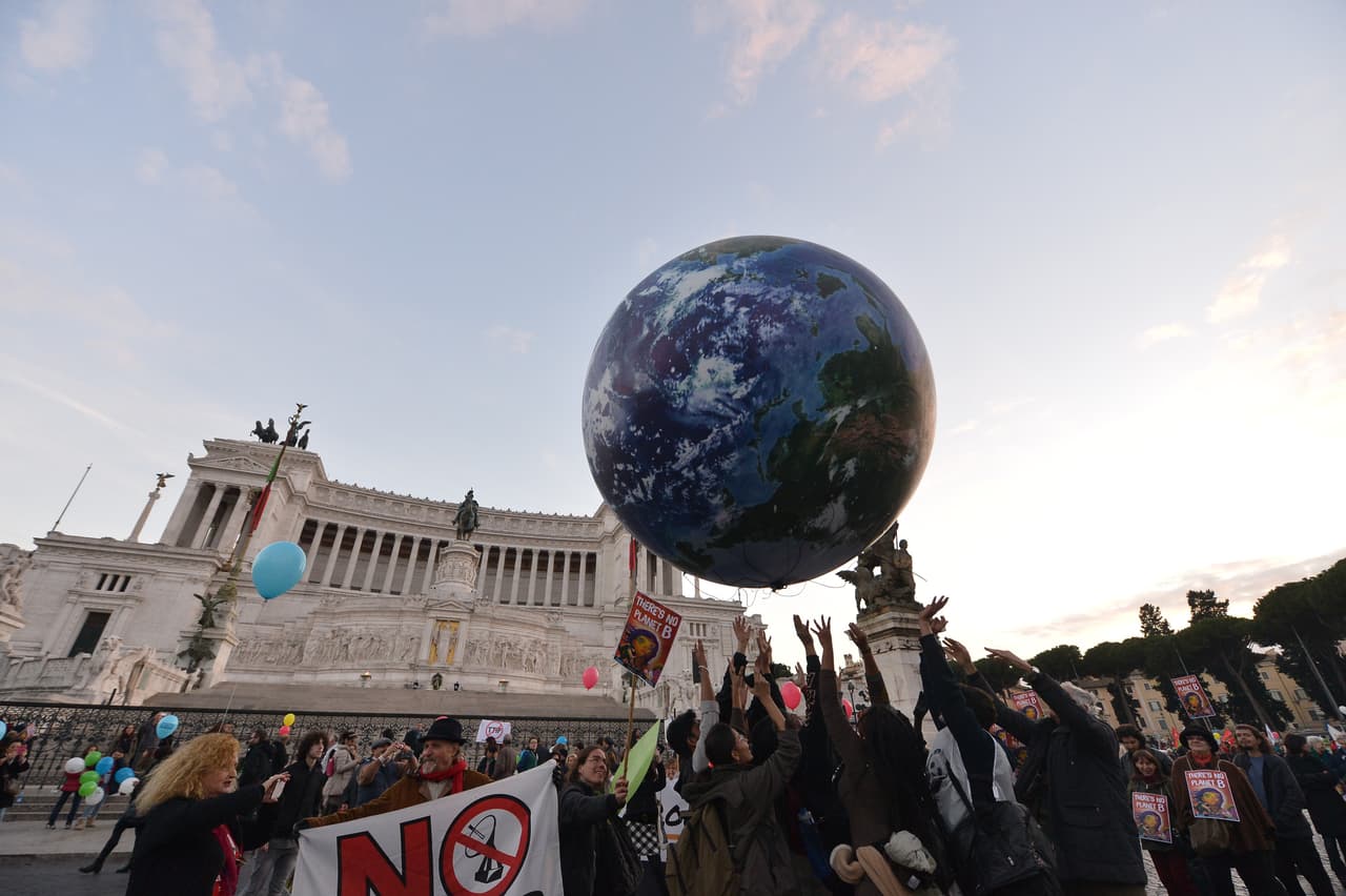 En la manifestación en la Piazza Venezia en Roma, la gente juega con un globo gigante que representa a la Tierra.