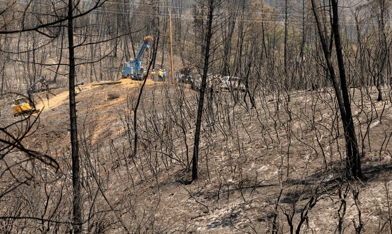 Bomberos revisan una zona afectada por un incendio en el condado de Shasta, en California, donde las temperaturas han alcanzado los 95ºF (35ºC).