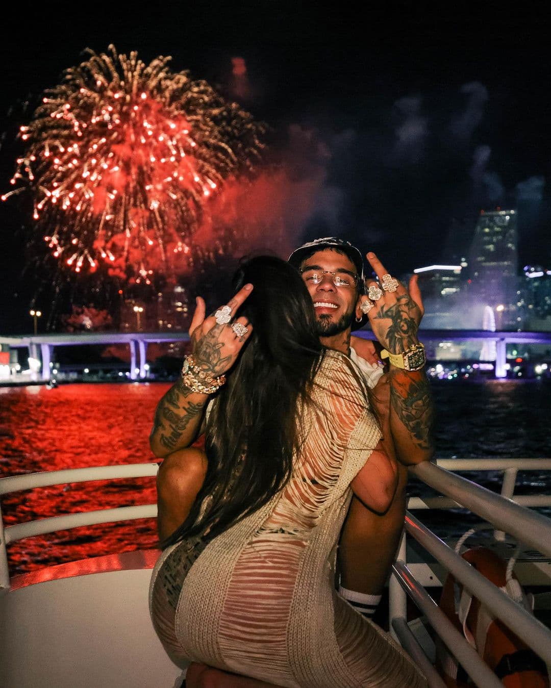 Se trata de esta foto en la que aparece de nueva cuenta con una misteriosa mujer quien está sentada de espaldas sobre él y lo abraza mientras el cantante parece gozar el momento en un paseo nocturno en yate y con fuegos artificiales en el cielo. 
<br>