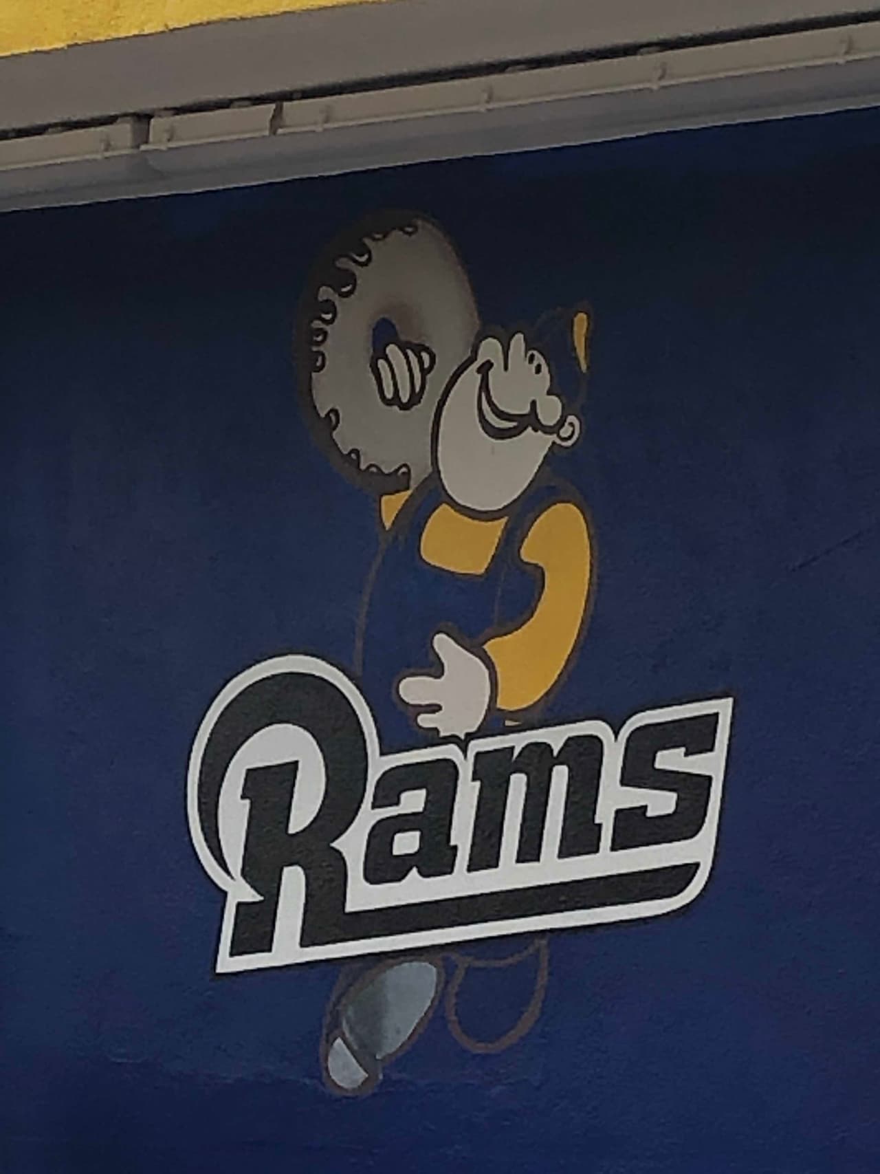 Se puede ver a la mascota oficial de la tienda de donas con el logo del equipo local