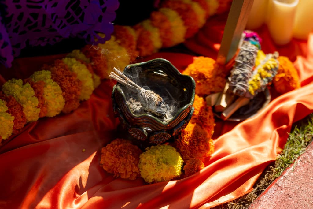 Cada altar contaba con cempasútchil, la flor que según la tradición, guarda en sus pétalos el calor del sol y lo usa para iluminar a los difuntos en su camino de reencuentro con sus seres amados. También incienso, para asegurar el ambiente estuviese limpio para el encuentro entre las almas, de acuerdo a los creyentes.