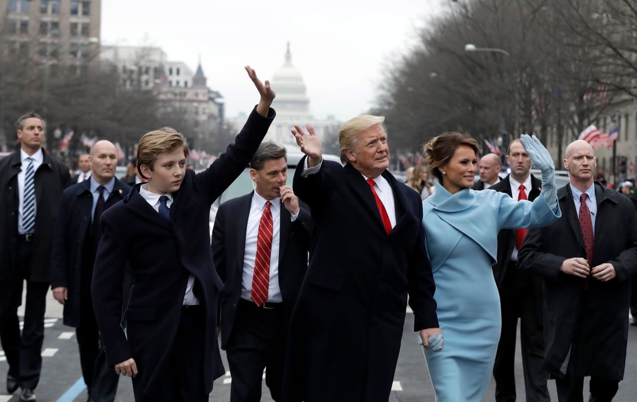 Donald Trump saluda a los simpatizantes durante el desfile con la primera dama Melania Trump y su hijo Barron Trump.
