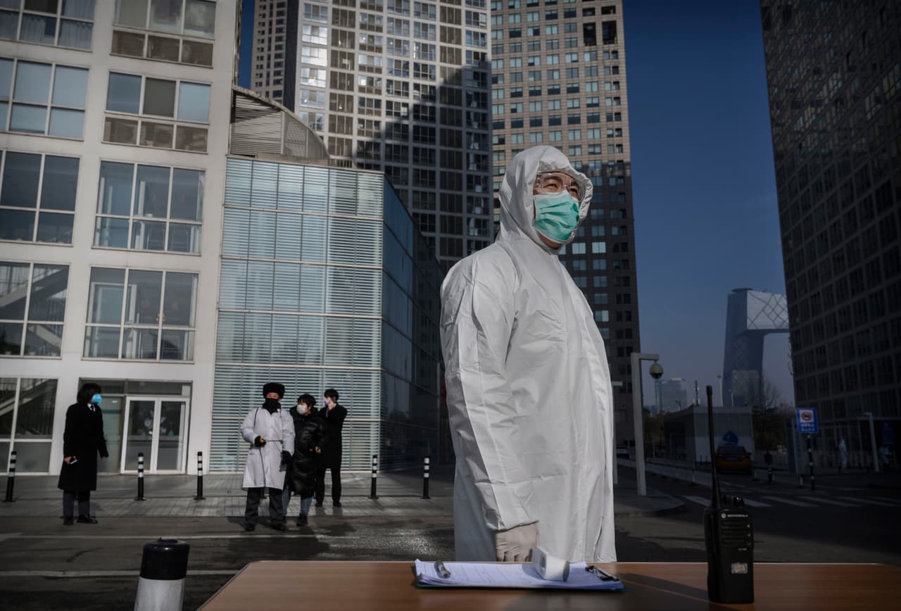 Un trabajador protegido con traje y máscara espera frente a un edificio de oficinas en Pekín. El grupo automovilístico alemán Volkswagen ha pospuesto la reapertura de algunas de sus fábricas en China y la reanudación de la producción por temor al coronavirus. Según reporte de la agencia EFE, la automotriz estudia la situación de cada fábrica por lo que el momento de reanudar la producción podría ser diferente en cada localidad.