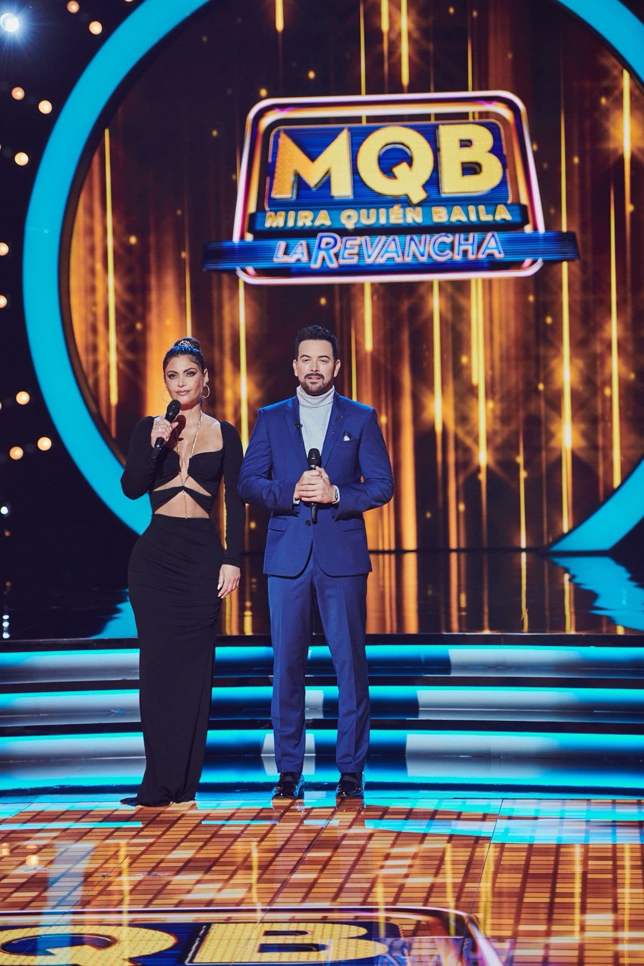 Por su parte, su entrañable compañero en las galas, Mane de la Parra eligió un traje en color azul índigo que contrastaba no sólo con la playera en cuello de tortuga sino también con el atuendo de la conductora.