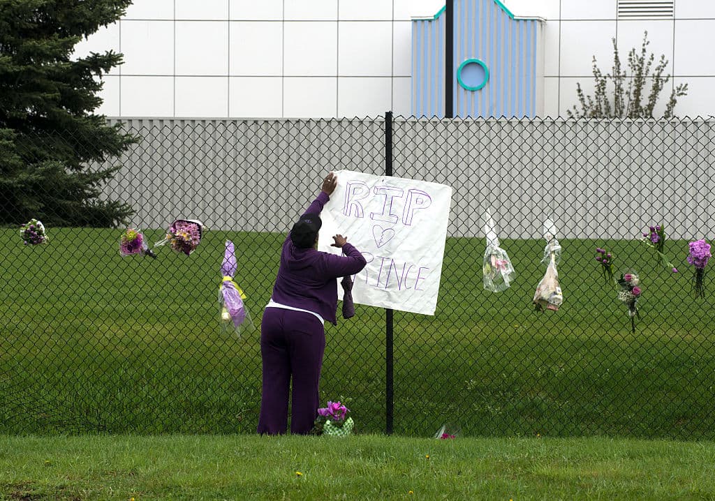 Una fan de Prince deja una recuerdo en la reja que rodea la casa del músico, ahora convertida en museo