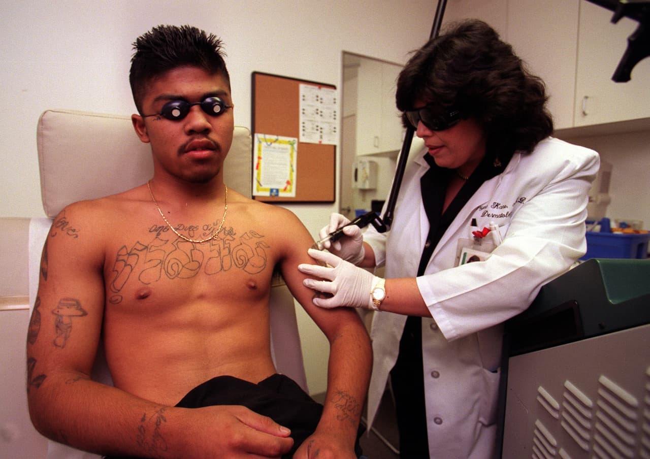 <b>Pandillas asiáticas. </b>Están conformadas por las bandas Tiny Rascal Gan, Boys In Style y Asian Boyz, entre otras. Operan en las ciudades con más población asiática del país e incluyen entre sus miembros a inmigrantes o descendientes de laosianos, camboyanos, vietnamitas, chinos, coreanos y filipinos. Se han encontrado en Massachusetts, Nueva York, Washington DC, Maryland, Connecticut, Georgia, Florida, Alabama, Texas, Oregon y California. Sus miembros han sido asociados a toda clase de actividades ilegales y se identifican con los símbolos orientales en general, dragones, panteras y tigres, entre otros. En la fotografía, tomada en 1998 en Long Beach, California, un ex miembro de la pandilla Asian Boyz hace un tratamiento gratuito para eliminar sus tatuajes.