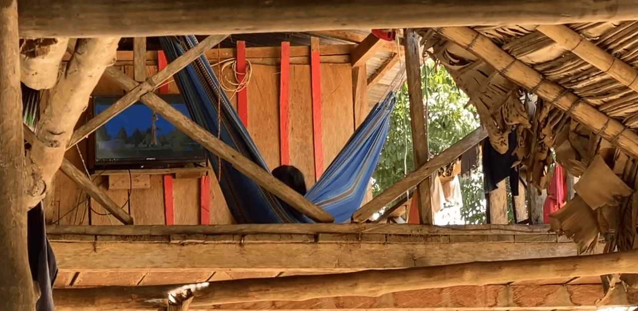 Niños de la comunidad Jiw viendo televisión en el segundo piso de una maloca.