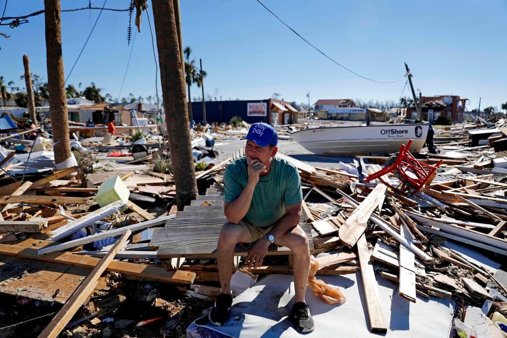Hector Morales se sienta en una pila de escombros el viernes 12 de octubre de 2018 cerca de su casa, la cual fue destruida por el huracán Michael en Mexico Beach, Florida. (AP Foto/David Goldman)