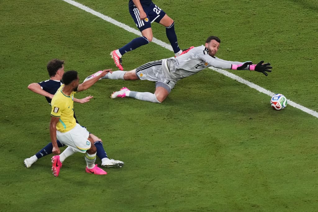 El brasileño Matheus Cunha marca un gol ante el portero de Escocia