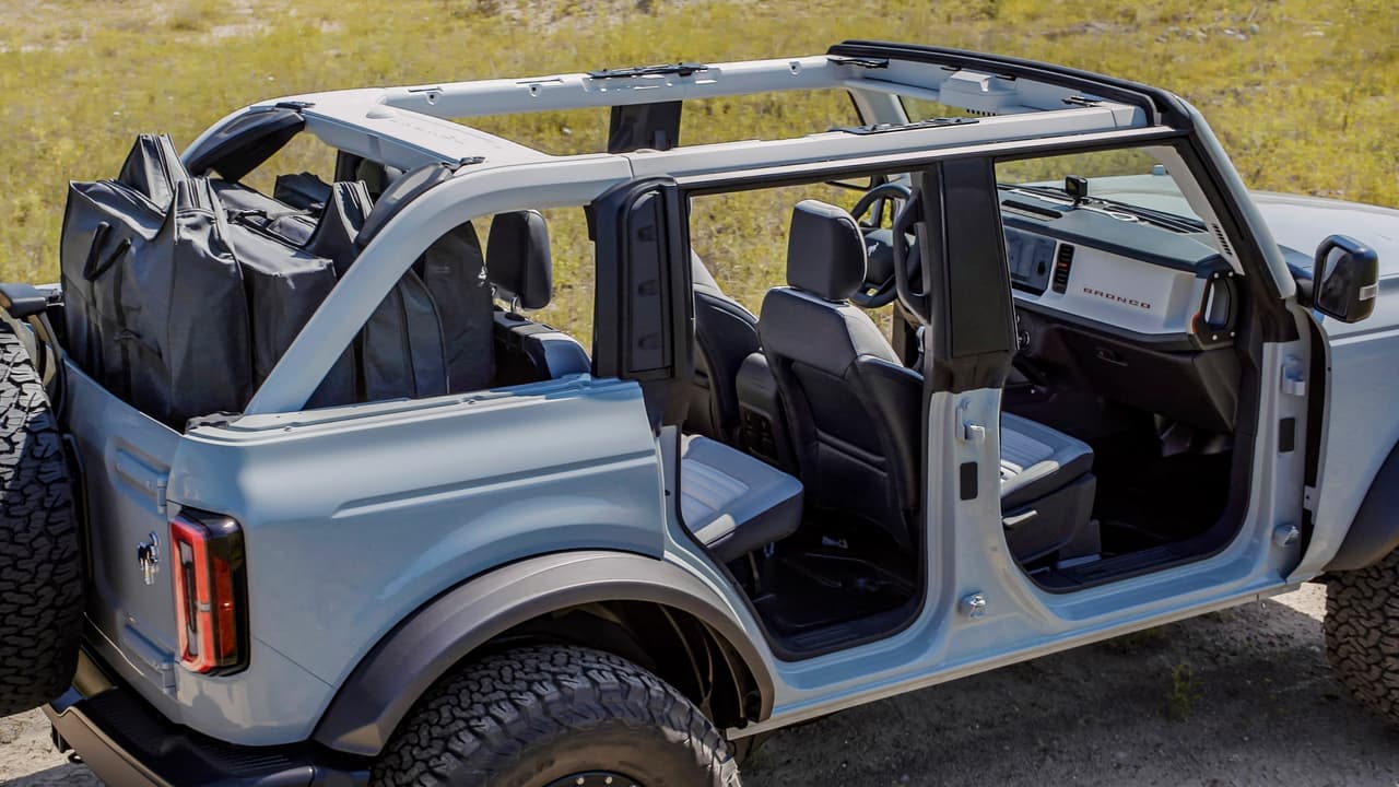 Every Bronco comes with class-exclusive frameless doors that make them easier to remove than what competitors offer. On four-door 2021 Bronco models, all doors can be stored onboard with protective door bags. Rear quarter windows are also removable, as shown on this four-door Bronco prototype. All have exclusive cowl-mounted mirrors to maintain sideview visibility when the doors are removed. (Prototype not representative of production vehicle.)