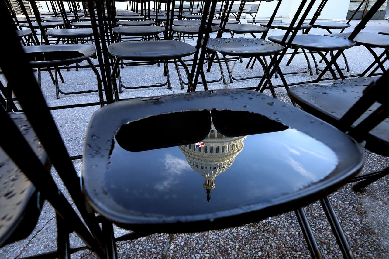 La cúpula del Capitolio se refleja en un pozo de agua en una de las sillas que se usó este domingo durante el ensayo para la toma de posesión de Donald Trump. El presidente electo juramentará como el presidente número 45.