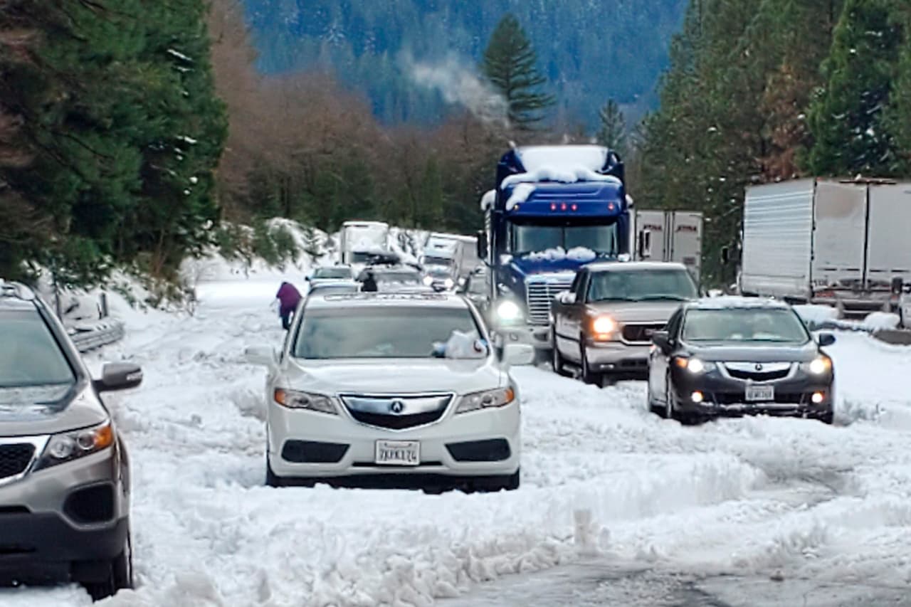 En esta foto distribuida por Caltrans, autos y camiones están detenidos en la nieve en la autopista Interestatal 5 cerca de Dunsmuir, California, este miércoles.