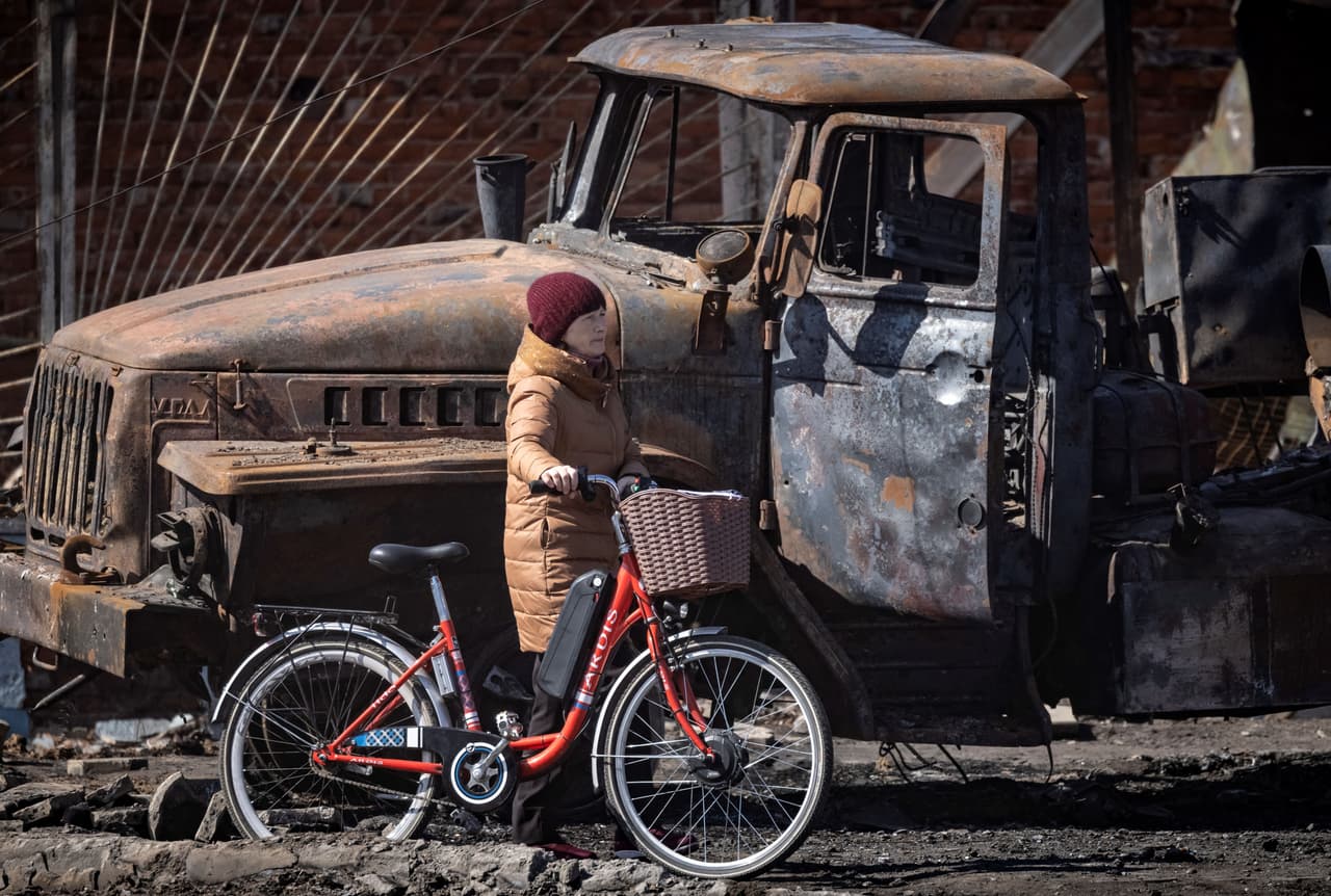 El residente Vitali Butski dijo que 
<b>"tres misiles alcanzaron su casa" </b>y que "muchos edificios más allá de la estación de tren están dañados". 
<br>
<br>Una mujer empuja su bicicleta cerca de un vehículo blindado en Trostianets. 
<br>