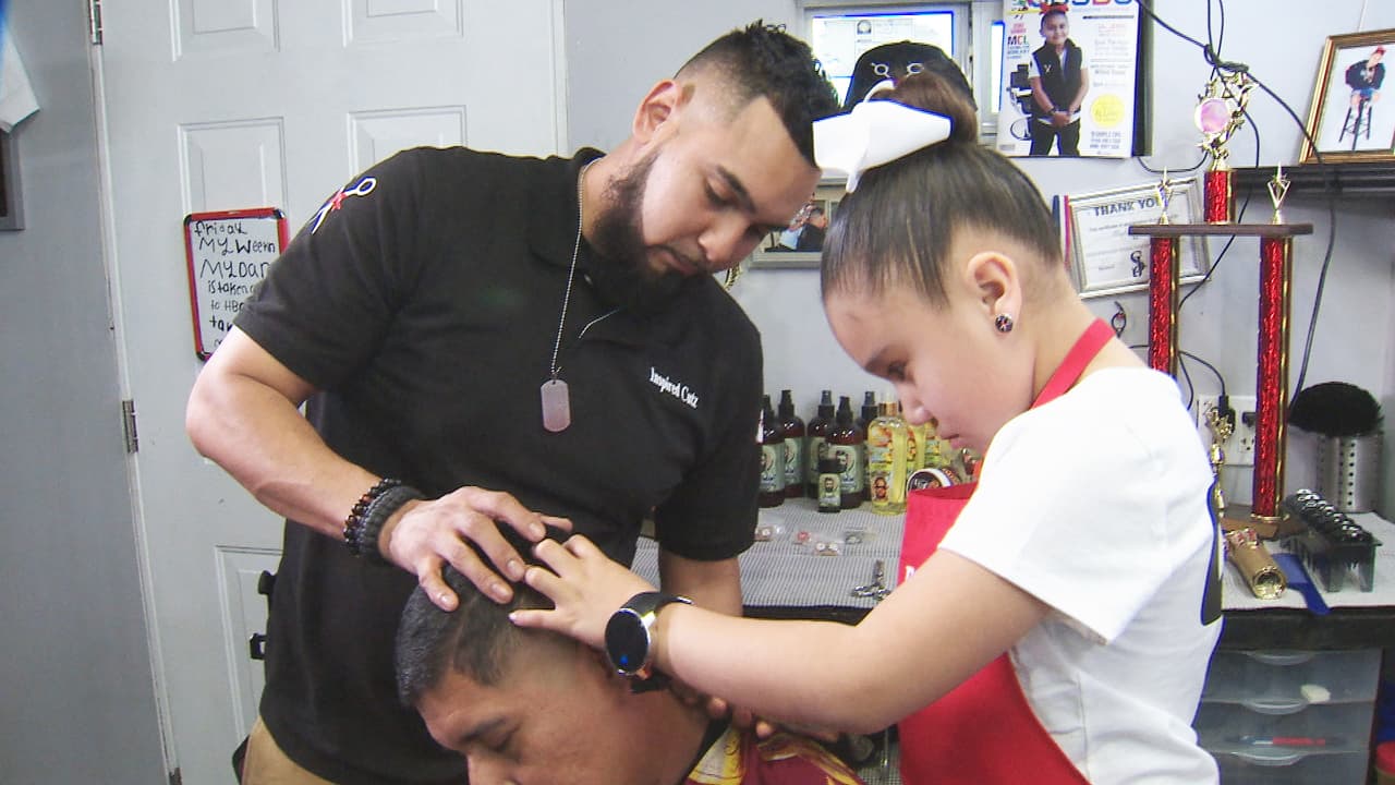 La pequeña peluquera atiende con mucha seguridad a los clientes en la peluquería de su familia, siempre con la supervisión de su padre, Franky Hernandez.