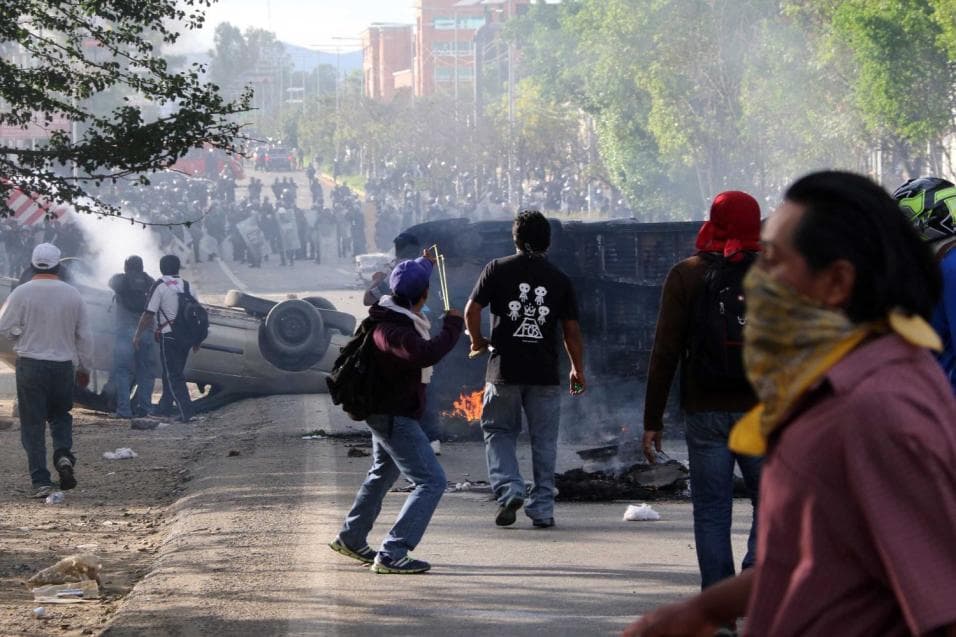 A man uses a slingshot to throw stones during a riot