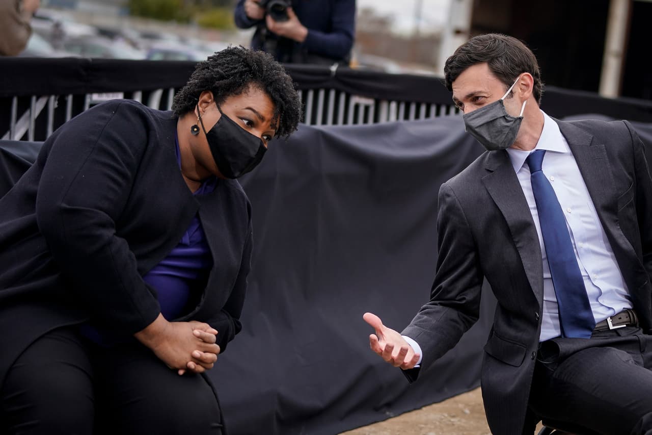 El candidato demócrata al Senado de los Estados Unidos, Jon Ossoff, habla con 
<b>Stacey Abrams</b> durante un mitin de campaña con el presidente electo de los Estados Unidos, Joe Biden. Para ganar el control, los demócratas deben derrotar a los dos senadores republicanos titulares del estado, David Perdue y Kelly Loeffler, en contiendas que han atraído la atención nacional y un importante dinero a esas campañas. Perdue se enfrenta a Jon Ossoff, mientras Loeffler al Rev. Raphael G. Warnock, pastor principal de la Iglesia Bautista Ebenezer en Atlanta.