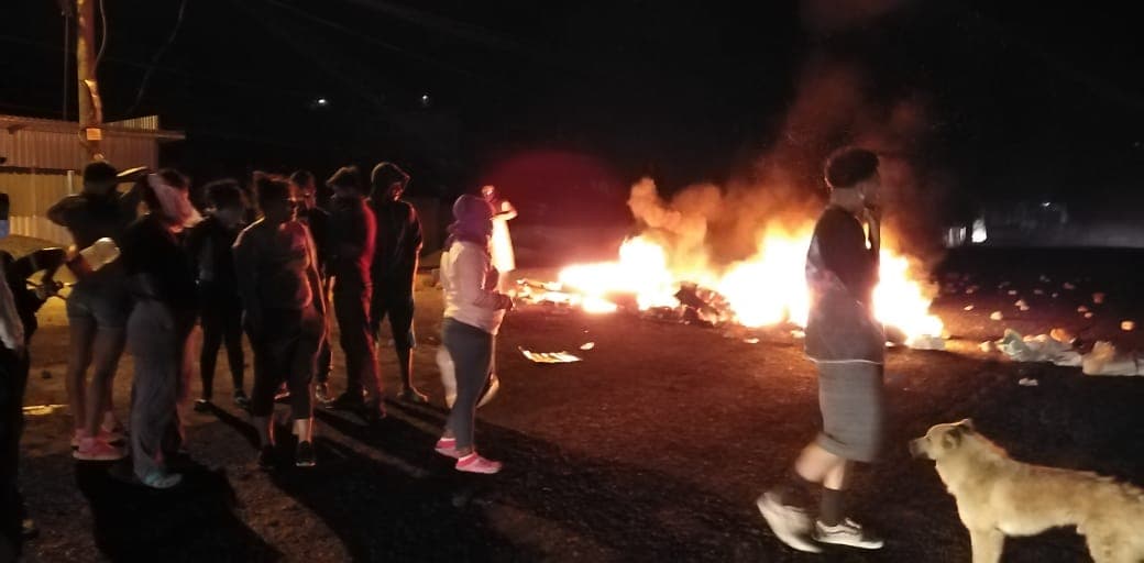 Encapuchado por el coronavirus, queman llantas y basura en protesta contra el gobierno en el barrio Villa Vieja, Tegucigalpa.