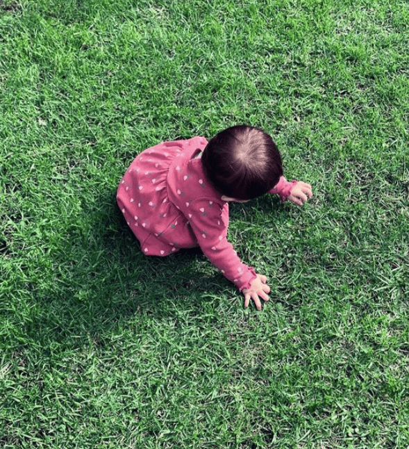 La pequeña María Paula gozó el momento, jugando con el pasto.