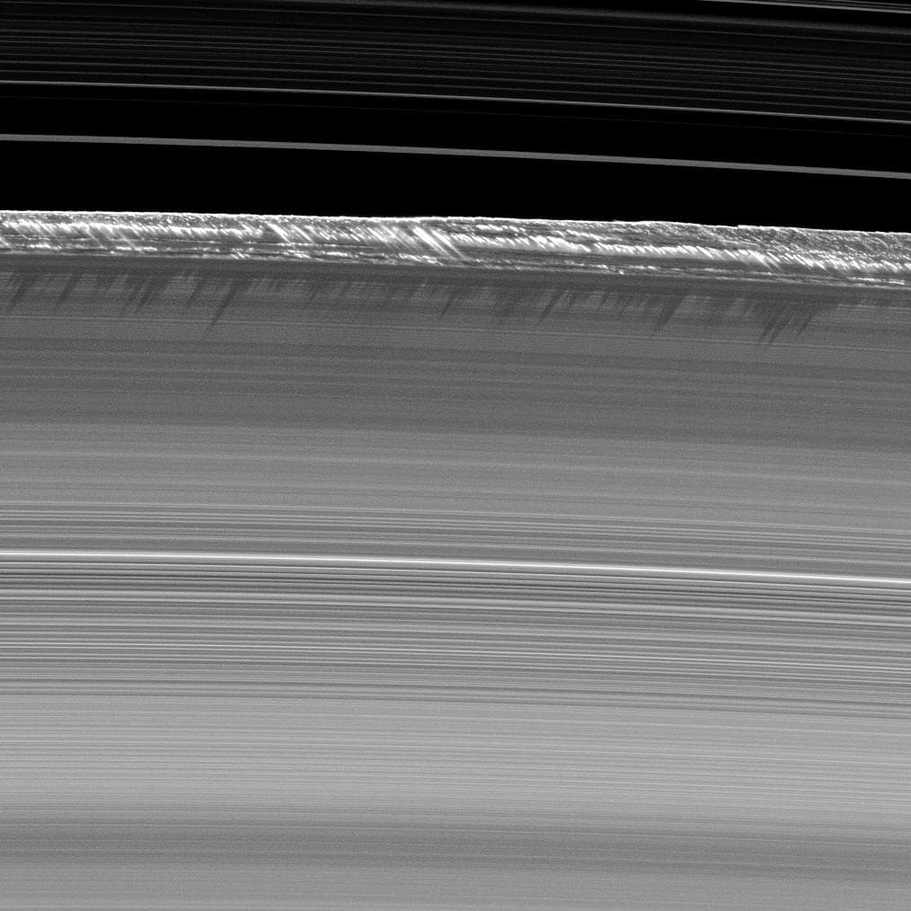 Las estructuras verticales de la imagen, entre las más altas vistas en los anillos principales de Saturno, se alzan desde el borde del anillo B de Saturno lanzando largas sombras sobre el mismo.