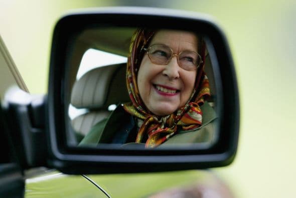 La reina Isabel II reflejada en el espejo retrovisor de su Land Rover.