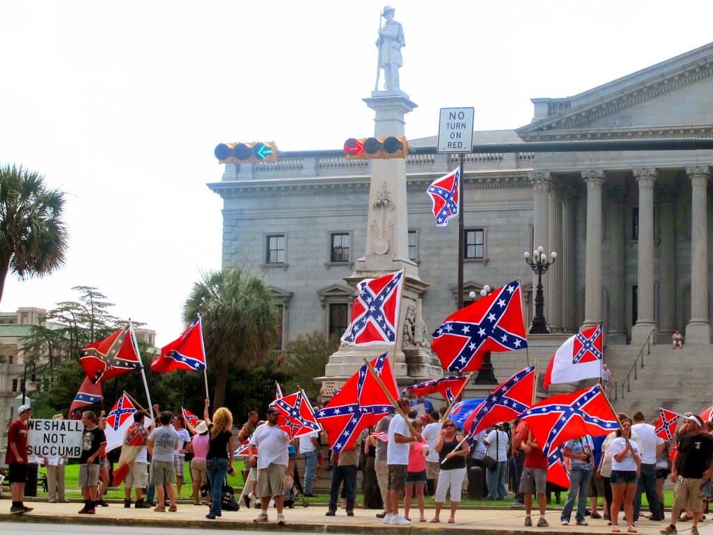 Los partidarios de mantener la bandera de batalla confederada en un monumento confederado en la legislatura estatal de Carolina del Sur ondean banderas durante un mitin frente a la legislatura estatal en Columbia, S.C., el sábado, 27 de junio de 2015.